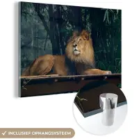 MuchoWow Glasschilderij 90x60 cm - Schilderij acrylglas - Leeuw - Bos - Wild - Foto op glas - Schilderijen