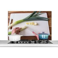 KitchenYeah Spatscherm keuken 100x65 cm - Kookplaat achterwand Het snijden van prei op een snijplank - Muurbeschermer - Spatwand fornuis - Hoogwaardig aluminium